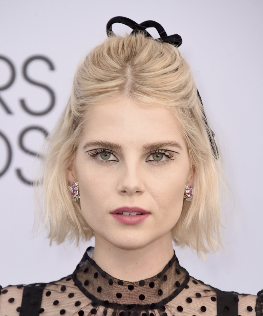 Lucy Boynton in a semi-updo with a bow for her bob haircut.