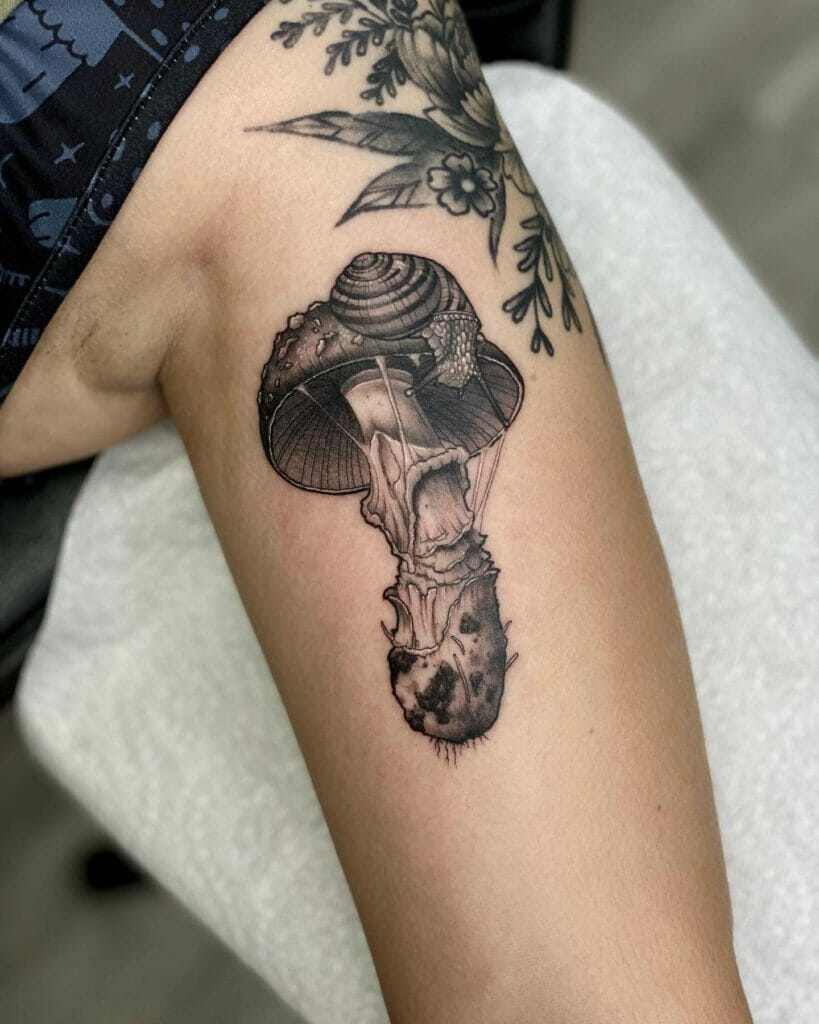 Black and gray tattoos of snails and mushrooms