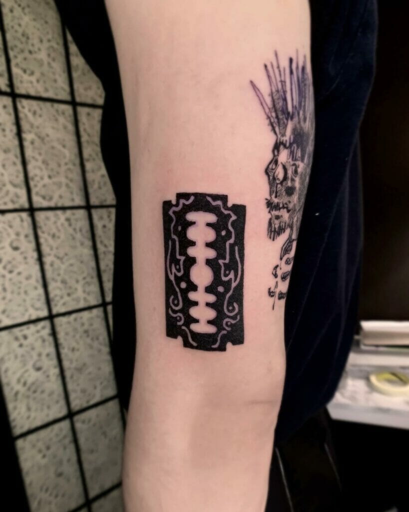 Patterned razor blade biceps tattoo 