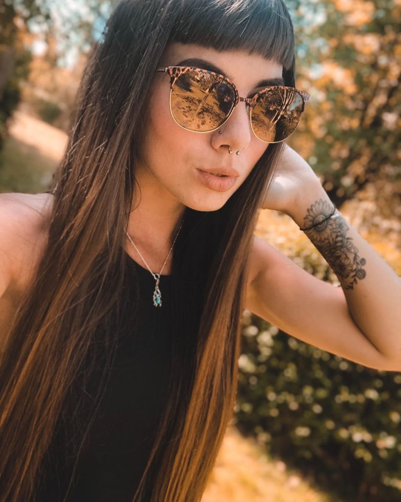 Hairstyle Ladies: Tattooed woman with sunglasses and short fringe. 