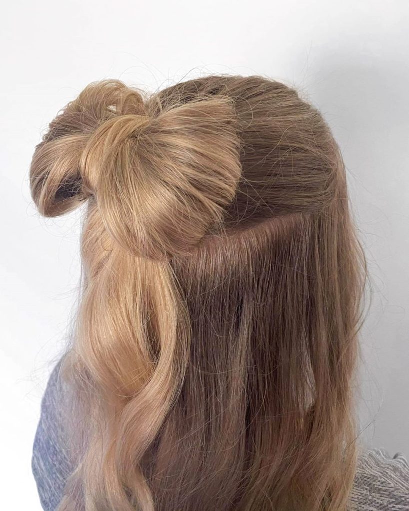 Women's hairstyle: woman with a bow made of her own hair on the back of her head.