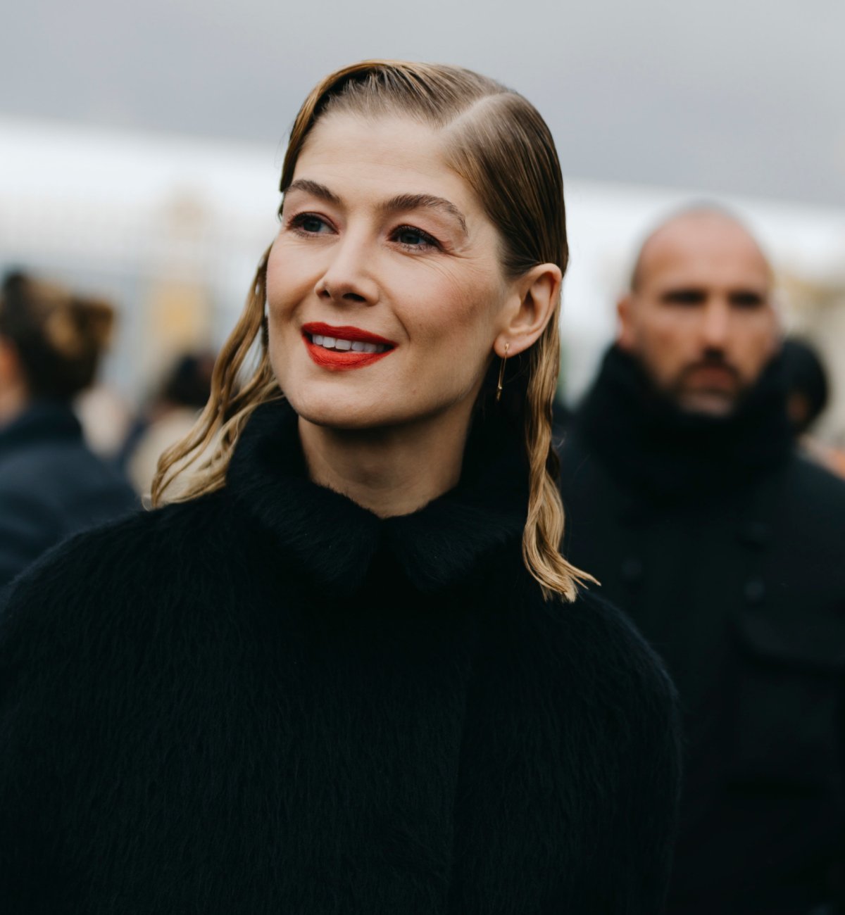 Rosamund Pike with wet-look hair parted in the middle.