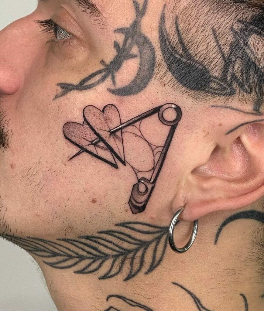 Safety pin heart face tattoo