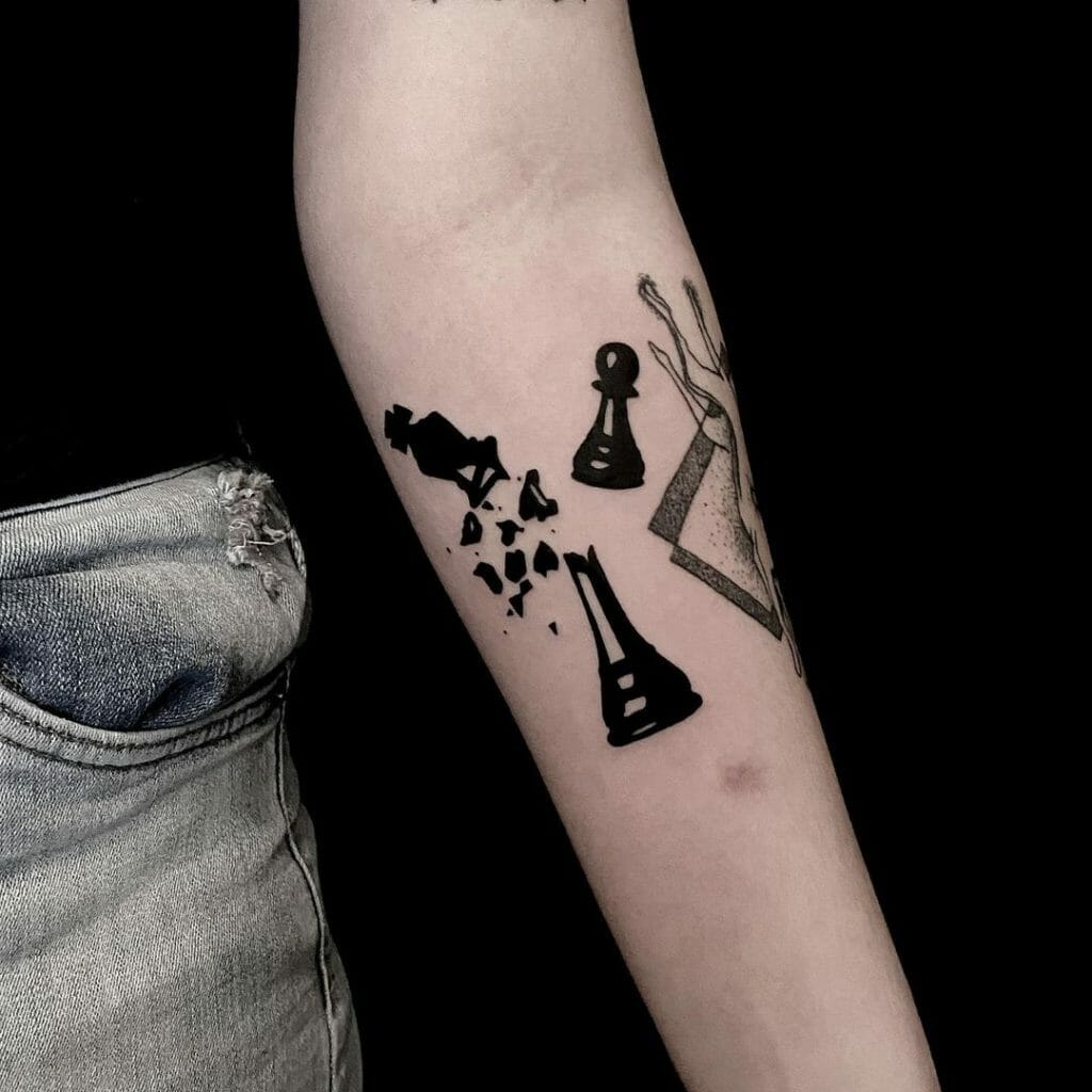 A black pawn with broken chess king piece tattoo