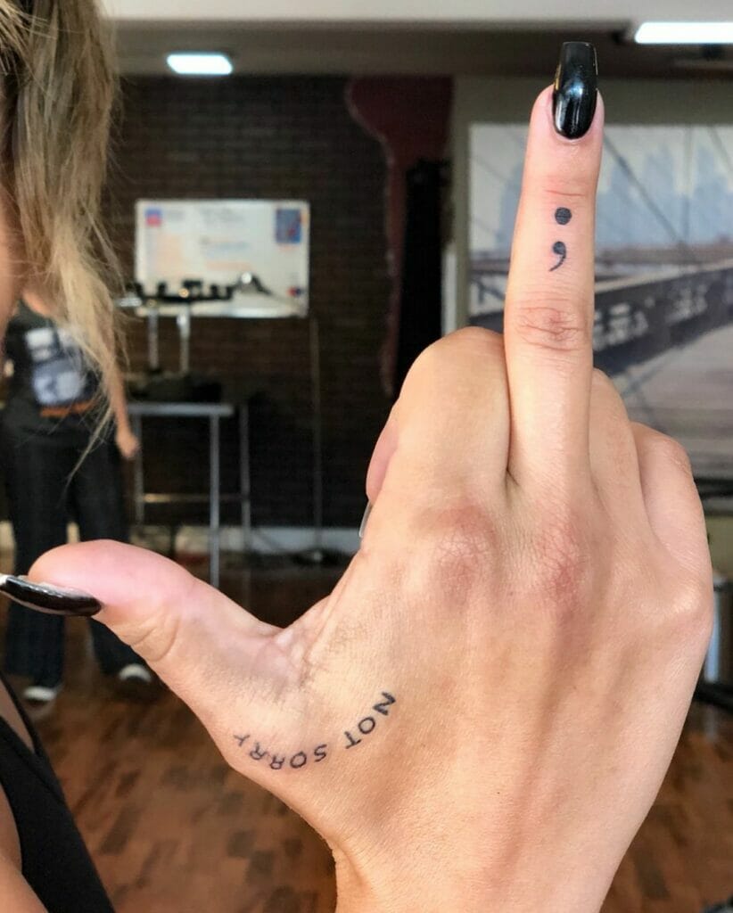 Ein Semikolon-Tattoo auf dem Mittelfinger