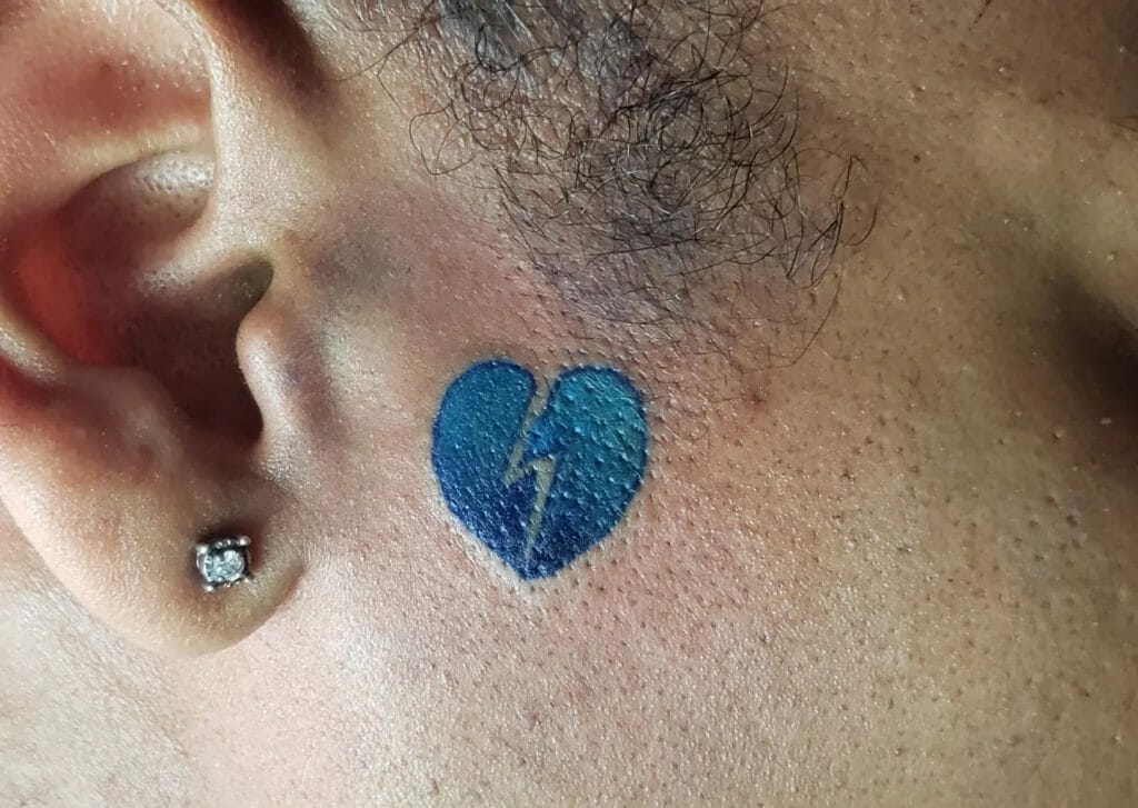Blaues Tattoo mit gebrochenem Herzen