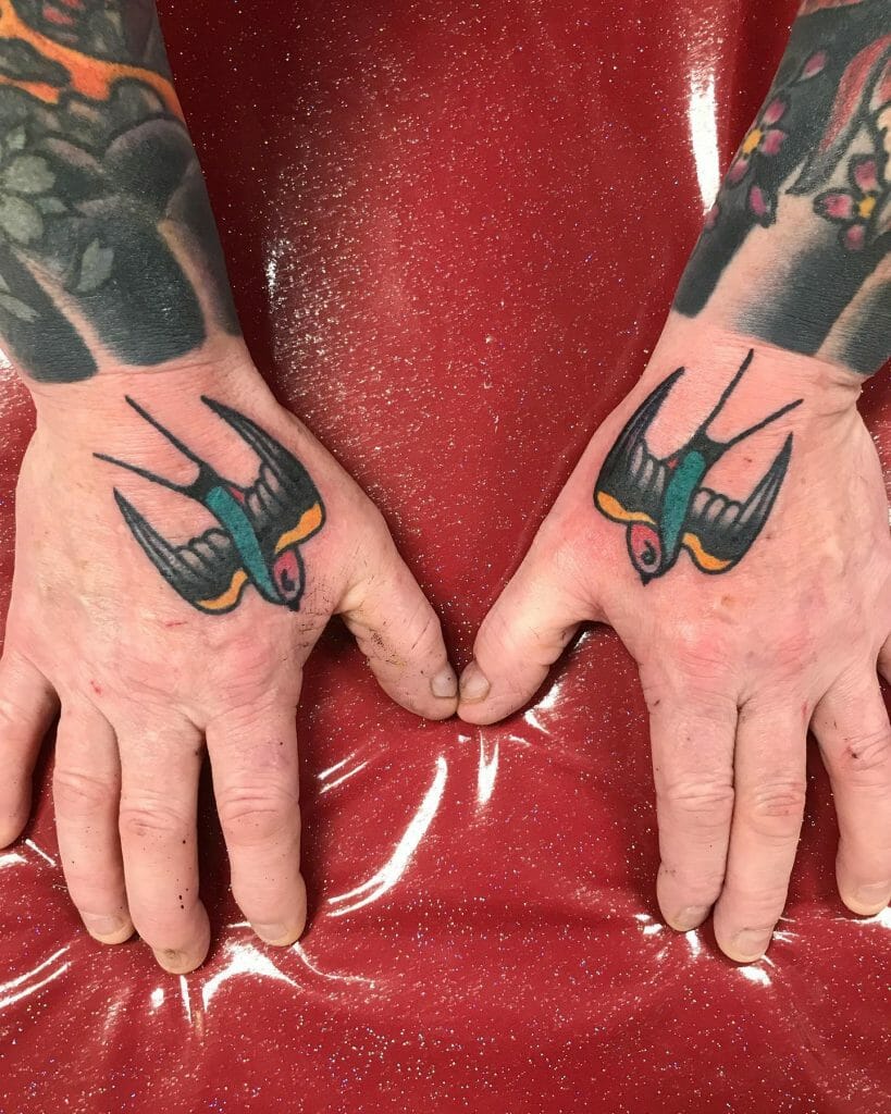 Colored swallow hand tattoo on both hands