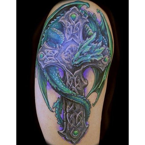 Intricate sleeve tattoo featuring a dragon and Celtic cross