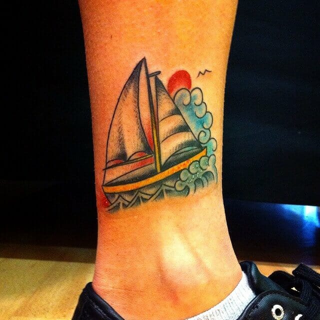 Small sailing boat tattoo done with vivid colors