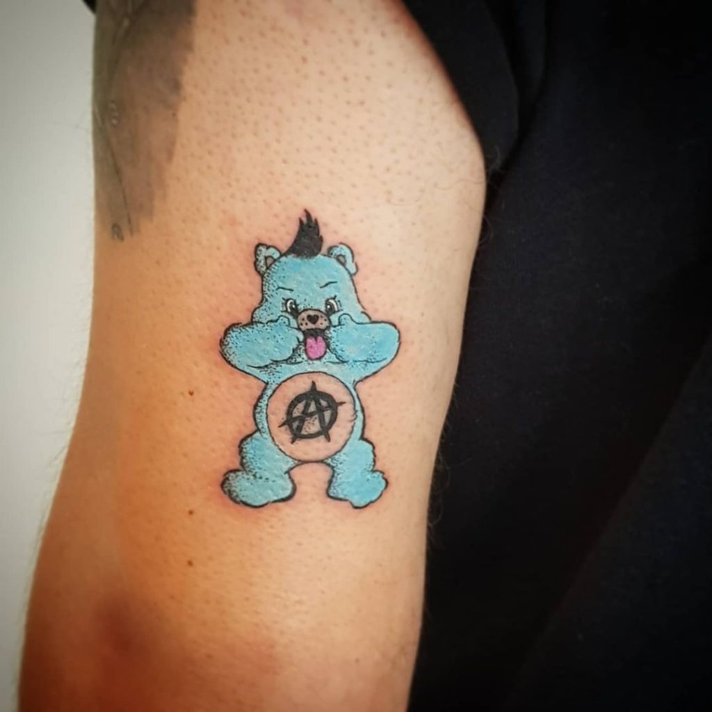 The anarchist Care Bear tattoo on the arm