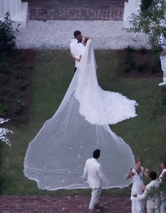 Savannah, GA - *PREMIUM EXCLUSIVE* - And the bride wore...white.  Jennifer Lopez wears a stunning white wedding dress as she celebrates her wedding to Ben Affleck, appropriately chic in a white jacket and black pants.  The couple kissed and posed at Ben's $8 million Georgia mansion on Saturday night before spending the night celebrating their love and union with family and a host of A-list friends.  All of the couple's children from their new blended family were also spotted walking a walkway leading to Ben's plantation-style home, with two of the boys wearing J Lo, now Jennifer Affleck's, incredible trains.  Pictured: Ben Affleck and Jennifer Lopez BACKGRID USA 20 AUGUST 2022 USA: +1 310 798 9111 / usasales@backgrid.com UK: +44 208 344 2007 / uksales@backgrid.com Publication*
