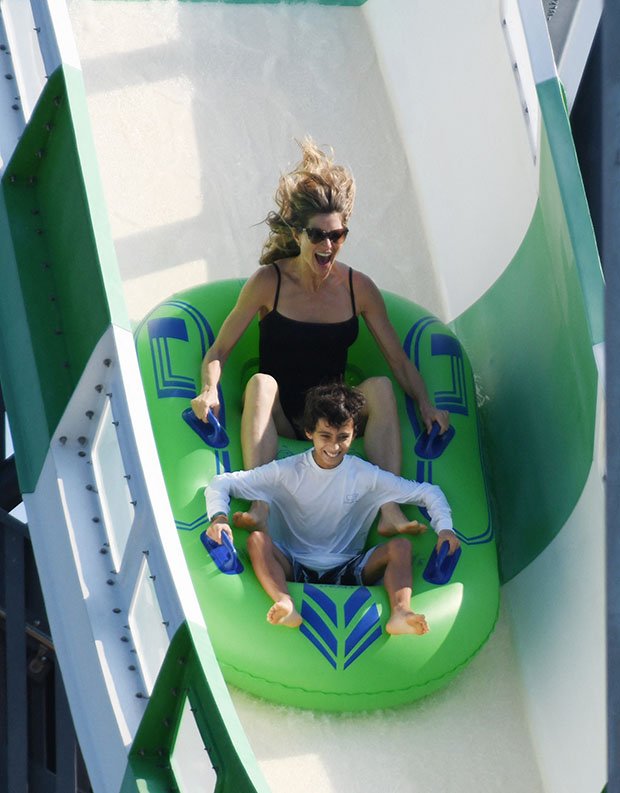 EXCLUSIVE: Newly single Gisele Bundchen wears a black swimsuit while having fun with her kids and their boyfriend on a waterslide in Miami.  11 Dec 2022 Pictured: Gisele Bundchen.  Photo credit: MEGA TheMegaAgency.com +1 888 505 6342 (Mega Agency TagID: MEGA925317_001.jpg) [Photo via Mega Agency]