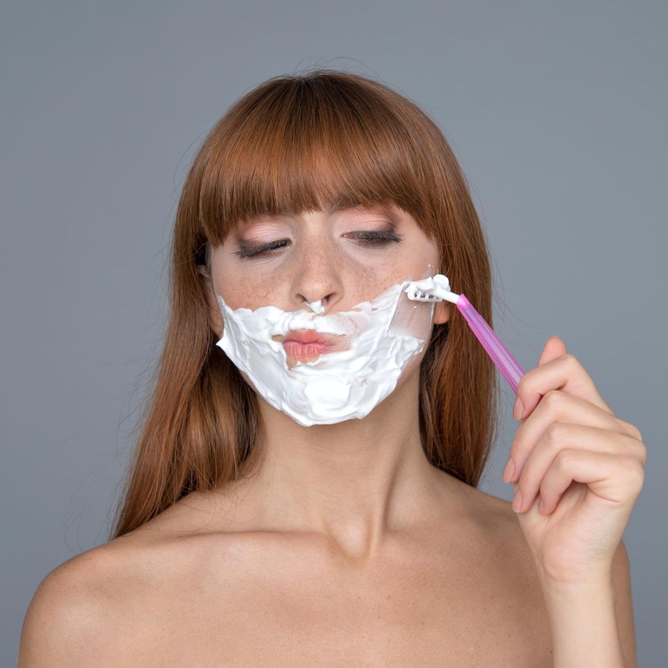 Shaving face: Woman with shaving cream on her face