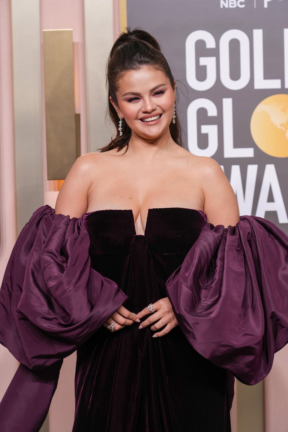 Selena Gomez chooses a robe in the darkest purple with extravagant puff sleeves in a different shade of purple