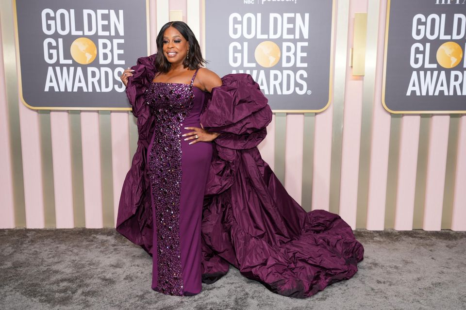 Niecy Nash wears a purple robe with lots of glitter