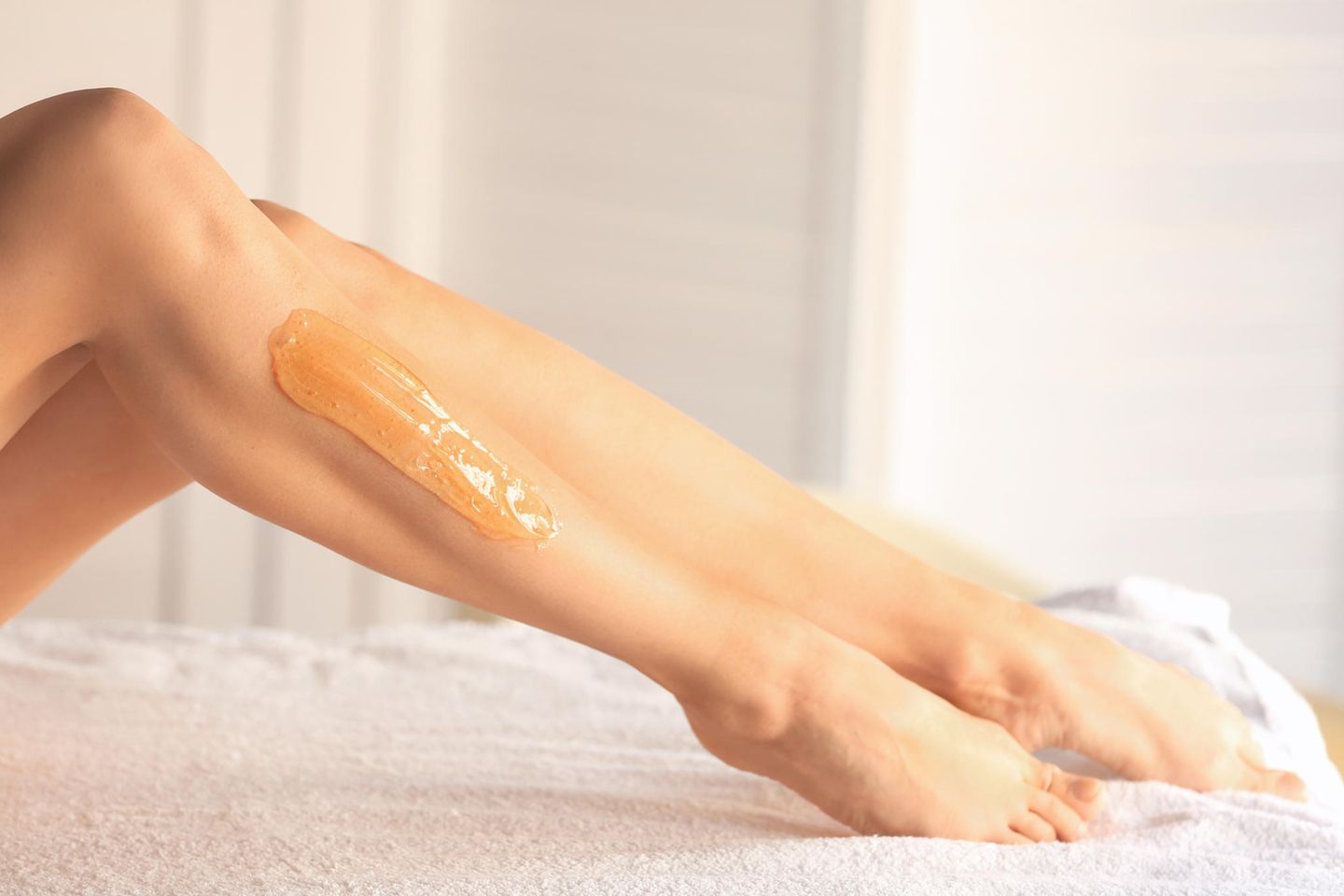 Sugaring paste: beautiful legs of a young woman with applied sugar paste