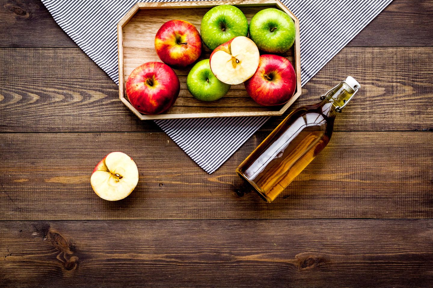 Apple Cider Vinegar Hair: Tray of apples on the table and a bottle of apple cider vinegar