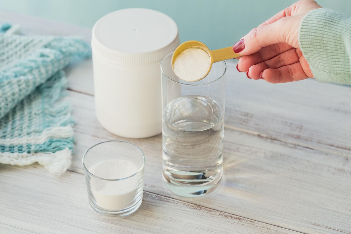 Woman mixes collagen powder in a glass with water