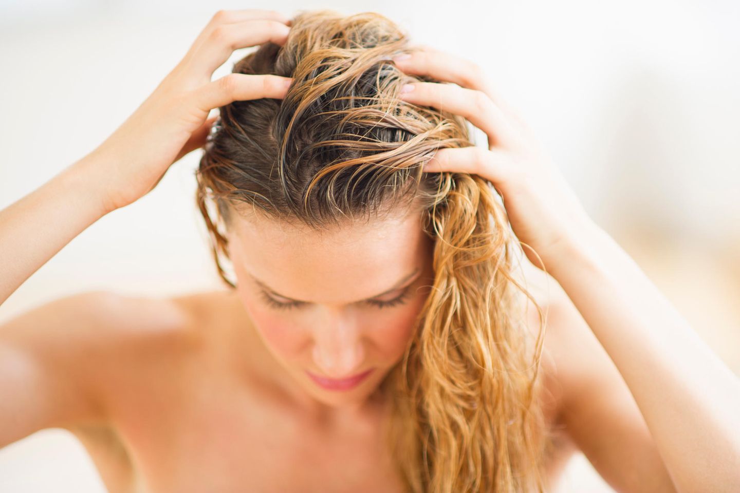 Burdock Root Hair Oil: Woman massaging oil into hair