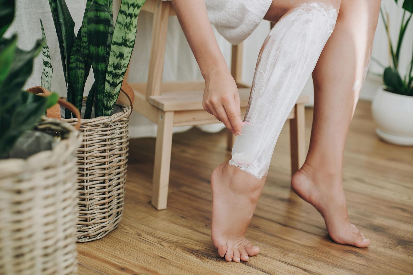 Depilatory cream: Woman depilates her legs with a depilatory cream