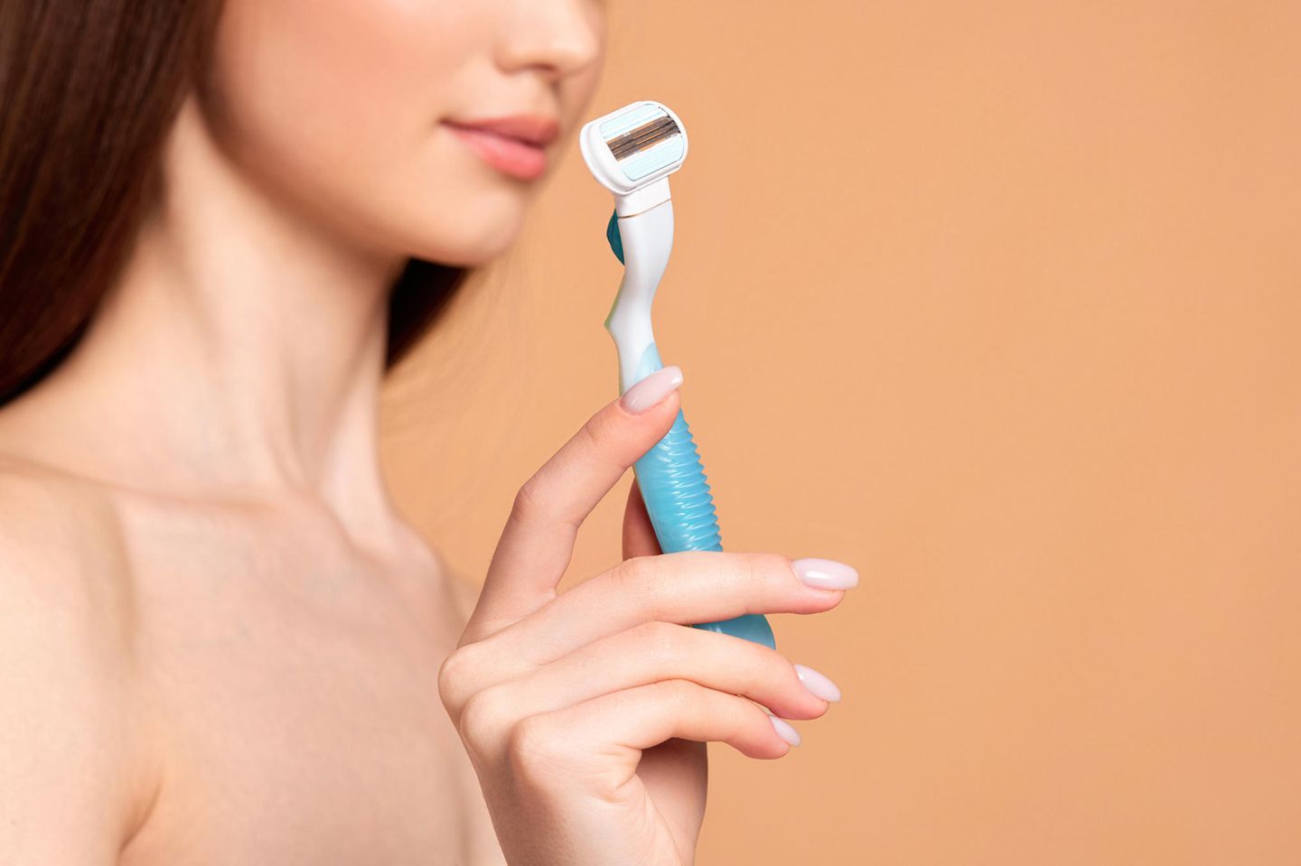 Intimate shave: woman holds wet razor